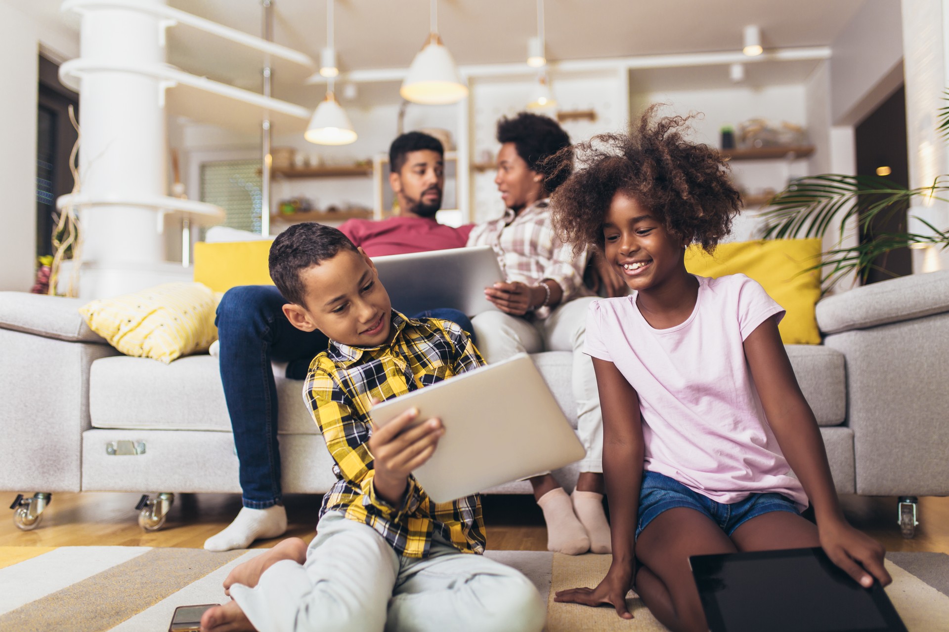 African american boy and girl lying on floor and using digital tablet.