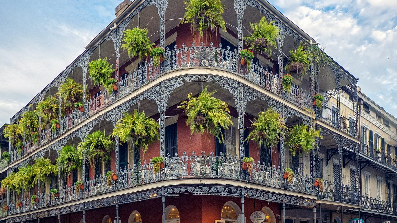A French Quarter street in New Orleans with iron balconies and historic buildings.