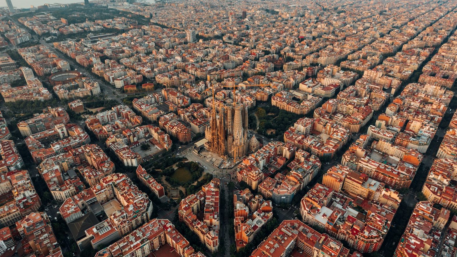 Aerial view of the Sagrada Família and the Barcelona city grid at dusk.